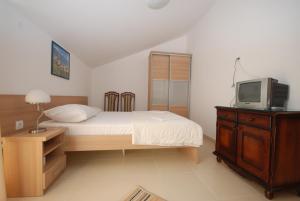 um quarto com uma cama e uma televisão numa cómoda em Pansion Anita em Budva
