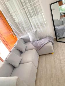 a living room with a couch and a mirror at LuckySmallie 1-Bed Apartment in Goba Dar es Salaam in Dar es Salaam