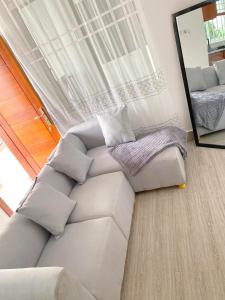 ダル・エス・サラームにあるLuckySmallie 1-Bed Apartment in Goba Dar es Salaamのソファと鏡のあるリビングルーム