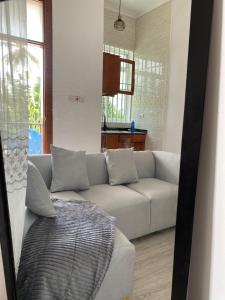 a living room with a white couch and a window at LuckySmallie 1-Bed Apartment in Goba Dar es Salaam in Dar es Salaam