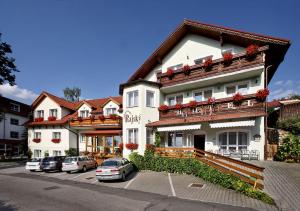 a large white building with cars parked in a parking lot at HOTEL RAJSKY in Český Krumlov