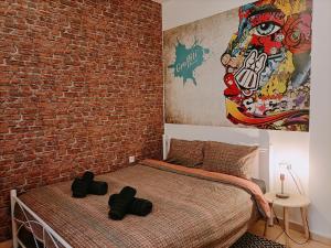 een slaapkamer met een bakstenen muur en een bed bij Thess Vibes @ City Center in Thessaloniki