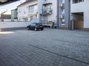 a car parked in a parking lot next to a building at APARTMANI INFINITY in Osijek
