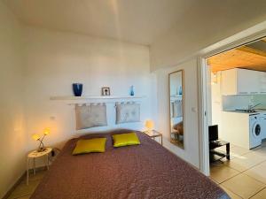 - une chambre avec un grand lit et 2 oreillers jaunes dans l'établissement Appartement Libeccio 42 LUMIO, à Lumio