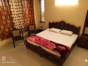 a bedroom with a bed with roses on it at Salas Executive in Mahabaleshwar