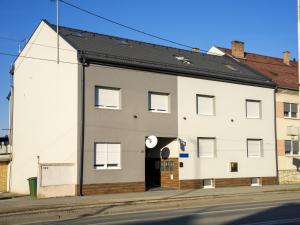 a white building on the side of a street at APARTMANI INFINITY in Osijek