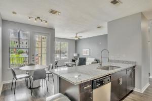a kitchen with a sink and a table with chairs at Landing Modern Apartment with Amazing Amenities (ID5692X84) in Tampa