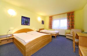 a hotel room with two beds and a desk at HOTEL RAJSKY in Český Krumlov