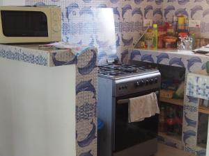 cocina con fogones y encimera en Maison Yaka, en Boukot Ouolof