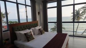 1 dormitorio con 1 cama y vistas al océano en Surf view resort en Ahangama