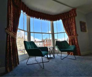 two chairs and a table in front of a large window at The Windmill Hotel - Alford in Alford