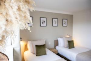 a hotel room with two beds and a christmas tree at Inn For All Seasons in Redruth