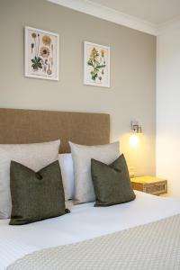 een slaapkamer met een bed met groene kussens bij Inn For All Seasons in Redruth