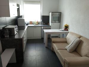 a living room with a couch and a kitchen at Betty Zimmer in Heilbronn Zentrum in Heilbronn