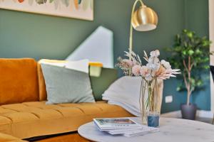 een vaas met bloemen op een tafel in een woonkamer bij Villa trifft Zeche by Cordis Sky für bis zu 7 Personen 5 Minuten zur Messe Essen und zum Hauptbahnhof Essen in Essen