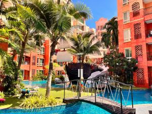 a pool at a resort with a slide and palm trees at Seven Seas Condo Resort in Jomtien Beach