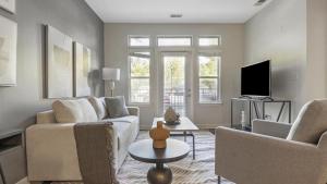 ein Wohnzimmer mit einem Sofa und einem TV in der Unterkunft Landing Modern Apartment with Amazing Amenities (ID9264X04) in Largo