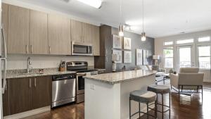 a kitchen with stainless steel appliances and wooden cabinets at Landing Modern Apartment with Amazing Amenities (ID9264X04) in Largo