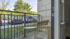einen Balkon mit zwei Stühlen und einem Geländer mit einem Parkplatz in der Unterkunft Landing Modern Apartment with Amazing Amenities (ID9264X04) in Largo
