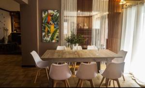 a dining room with a table and white chairs at Koùros apartment! in Piraeus