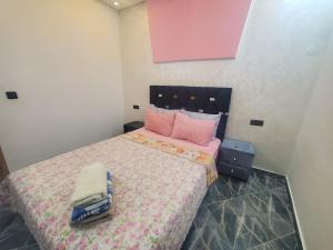 - une chambre avec un grand lit et des oreillers roses dans l'établissement Dar Brahim, à Chefchaouen