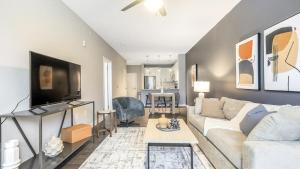 ein Wohnzimmer mit einem Sofa und einem TV in der Unterkunft Landing Modern Apartment with Amazing Amenities (ID8112X15) in Chapel Hill