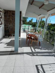 un tavolo e sedie di legno su un patio di VILLA HELENA a Bouillante