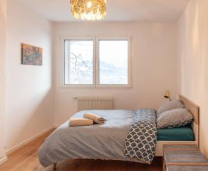 1 dormitorio con cama y ventana en Le toit de Chardonne - Entre Alpes et lac Léman, en Chardonne