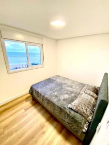 een slaapkamer met een bed in een kamer met een raam bij Apto em Navegantes/Gravatá in Navegantes