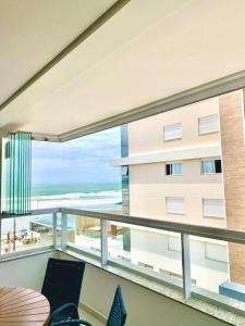 een balkon met uitzicht op een gebouw en de oceaan bij Apto em Navegantes/Gravatá in Navegantes