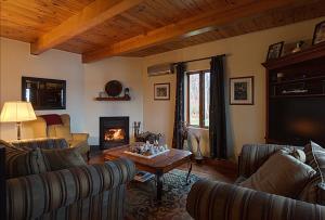 a living room with couches and a table and a fireplace at Chalet des bouleaux in Nominingue