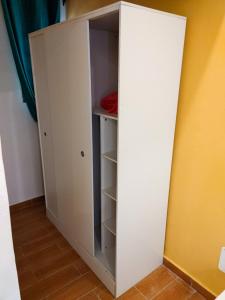 einen Schrank mit einem weißen Schrank in einem Zimmer in der Unterkunft LES 9 PLURIELLES - Studio 5 in Palimé