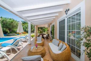 a patio with wicker furniture and a swimming pool at Zante Sun I - Getaway Villa! in Zakynthos