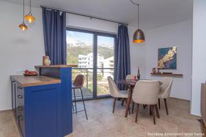 eine Küche und ein Esszimmer mit einem Tisch und Stühlen in der Unterkunft The Dream Getaway & Spa by DeVasco in Becici