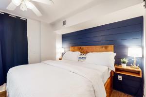 a bedroom with a large bed with a blue accent wall at USNA Getaway in Annapolis