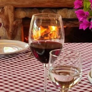 ein Glas Wein und ein Glas Wasser auf dem Tisch in der Unterkunft Fazenda pedra selada in Visconde De Maua