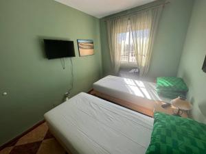 a bedroom with two beds and a tv and a window at Moto Vila Groot in Tabernas