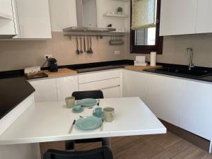 a kitchen with a white table with dishes on it at Hospitami Apartment - 15 min Duomo Milano in Milan +32 photos