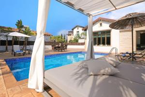 アヤナパにあるVilla Lara - 3bed Bangalow with Large Poolのスイミングプールの横にあるベッド(傘付) +31枚の写真