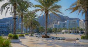 a resort with palm trees and a beach and buildings at Capital Stay - 2 Bed Apartment- The Address Fujairah in Fujairah