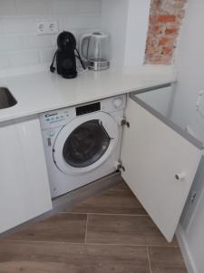 una cocina con lavadora bajo una barra en Francos Rodriguez2 Apartments, en Madrid