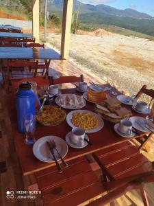 a table with plates of food on it at Pousada Mirante Das Serras Ibicoara-BA in Ibicoara