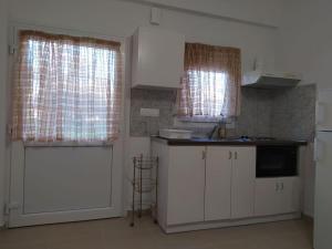 a kitchen with white cabinets and a white door at Creta Irini's Rooms3 in Tympáki +38 photos