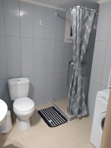 een badkamer met een toilet en een douchegordijn bij Creta Irini's Rooms3 in Tympáki