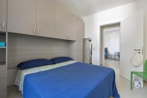 1 dormitorio con 1 cama azul y armarios blancos en Appartamento Paradise by BarbarHouse, en Santa Caterina di Nardò