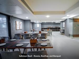 a dining room with tables and chairs in a restaurant at Saltstayz Basil - Near Golf Course Road & Extension Road in Gurgaon