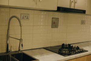 Una encimera de cocina con un fregadero y una estufa. en Atelier Lux Homes- Modern Service Apartments with Amazing Designs, en Ibadán 34 fotos más