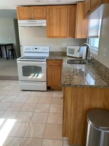 eine Küche mit weißem Herd und Spüle in der Unterkunft Bradley Beach Cozy Retreat in Bradley Beach