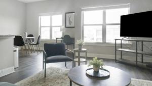 - un salon avec une télévision, une table et des chaises dans l'établissement Landing Modern Apartment with Amazing Amenities (ID3766X51), à Gonzales