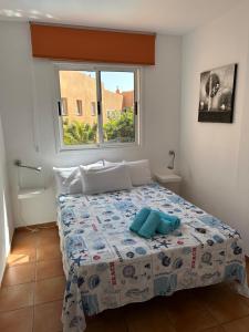 Dormitorio pequeño con cama y ventana en Casa Orange Piscine Terrasse Parking en San Sebastián de la Gomera